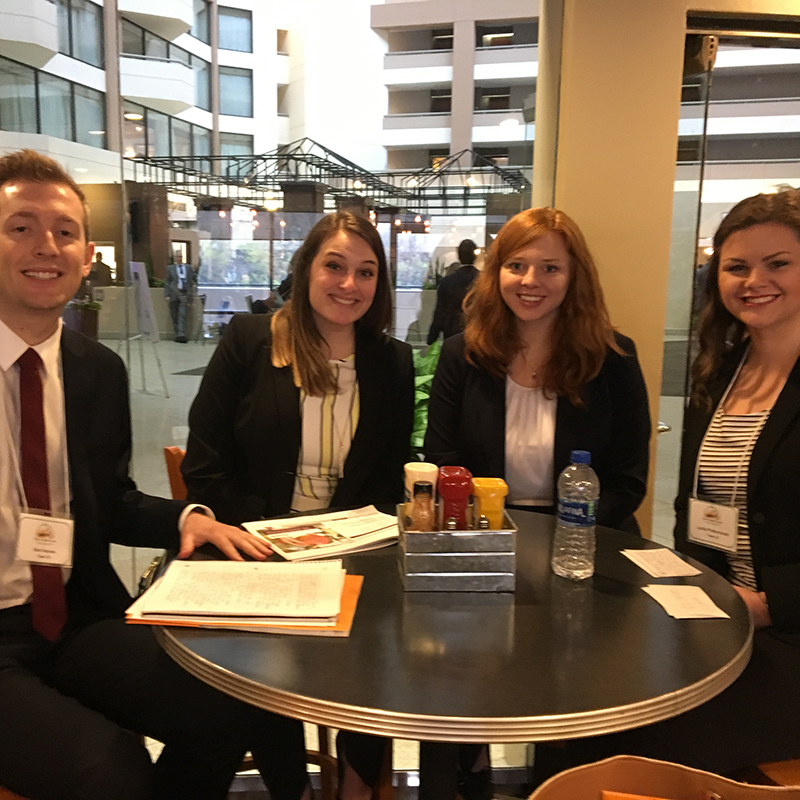 four graduate students sit around a table at the UAB Health Administration Case Competition