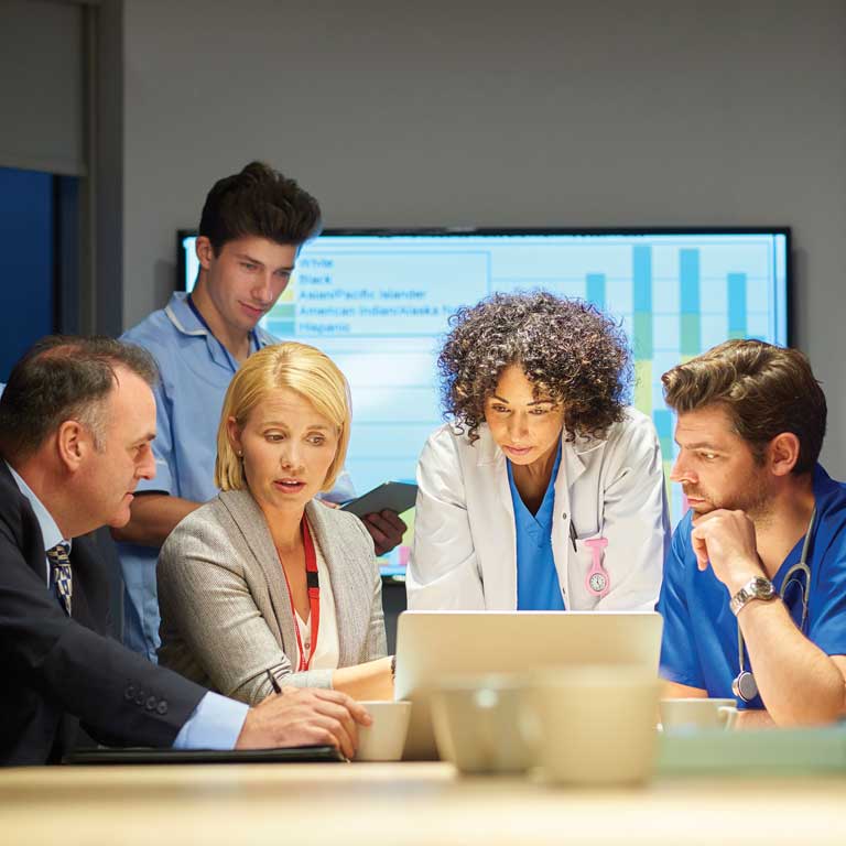 health administrators, executives, and doctors looking at a computer screen